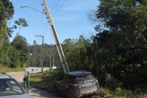 Range Rover colide em poste e deixa fiação caída sobre carro em Guabiruba