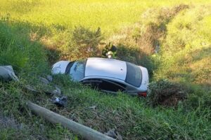 Carro colide contra poste, motorista fica ferido e fios caem sobre a pista em Ilhota